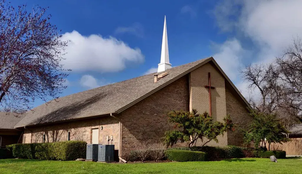 The Fairpark Baptist Church building with its white steeple on Crowley Road