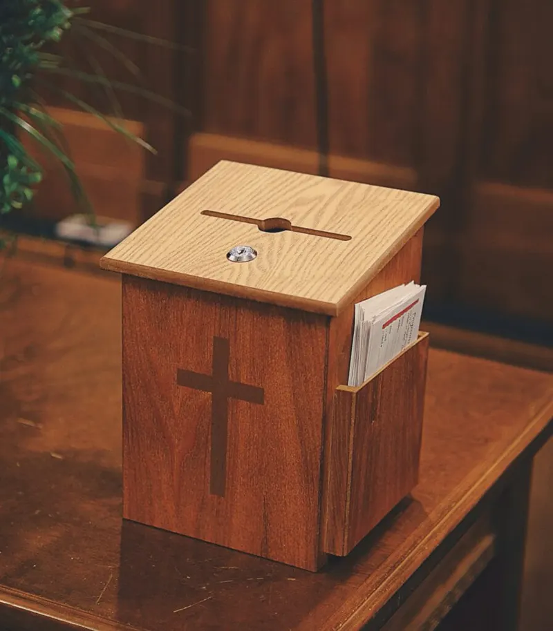 A wooden offering box with a cross on the front